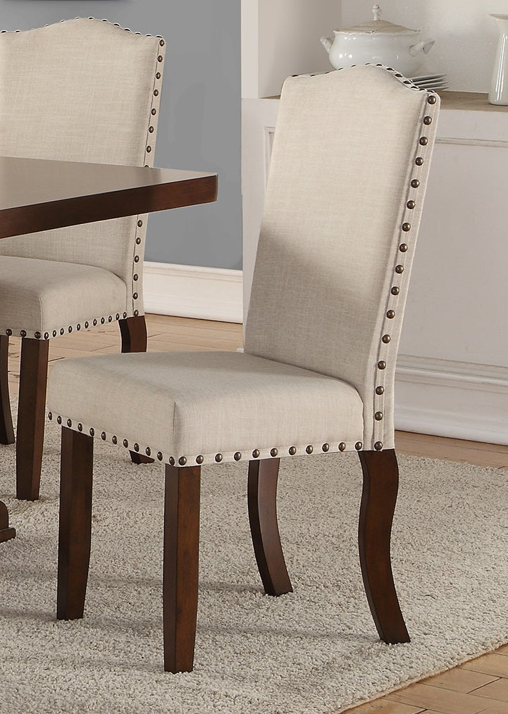 Upholstered dining chair in light beige linen with nailhead trim and dark wood legs