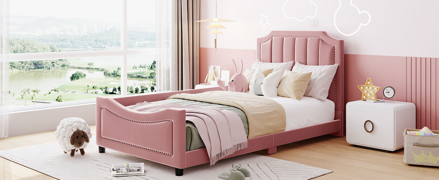 Pink velvet twin bed with upholstered headboard and safety rails