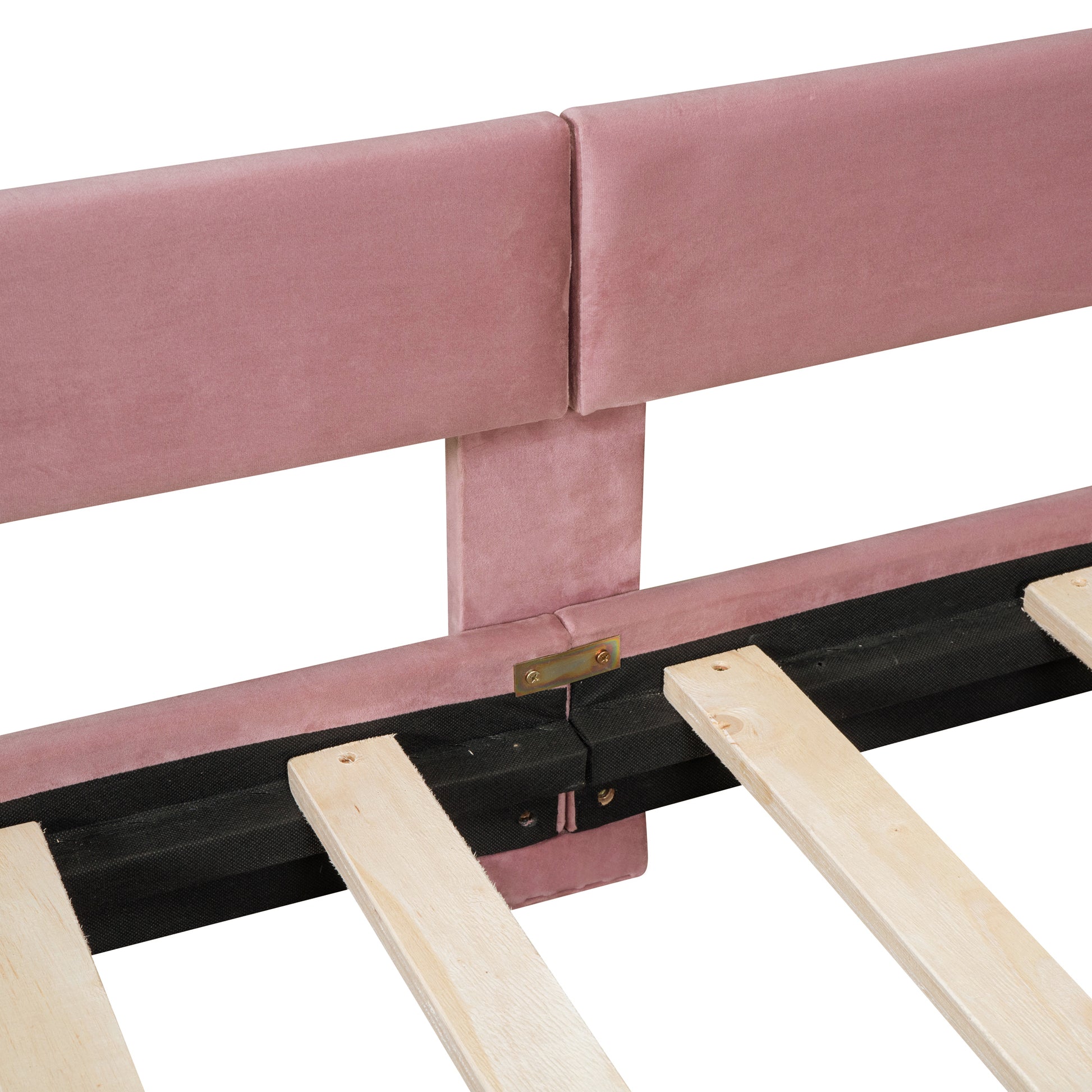 Close up of pink velvet headboard upholstery and wooden bed slats