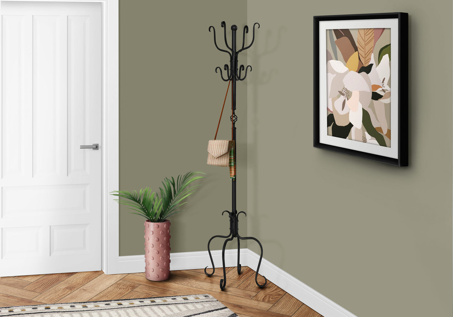 Black wrought iron coat rack with ornate scrolling base and curved hooks