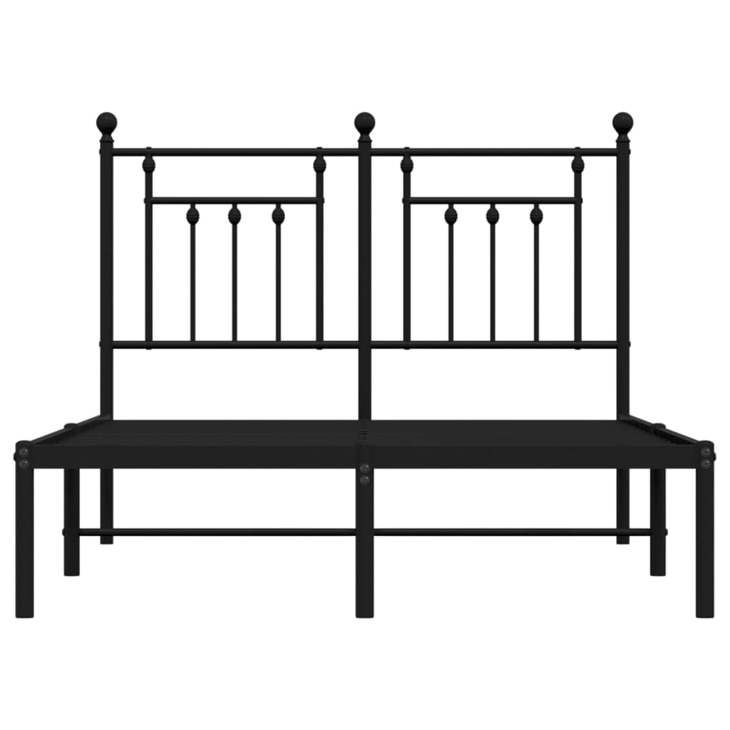 Black metal bed frame with a white mattress and ornate headboard
