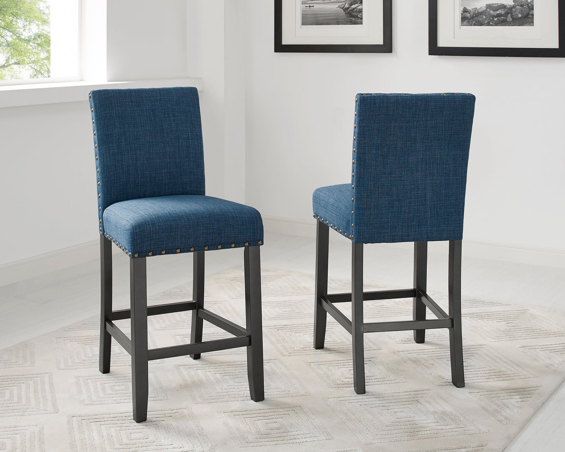 Blue upholstered bar stool with brass nailhead trim and dark wood legs