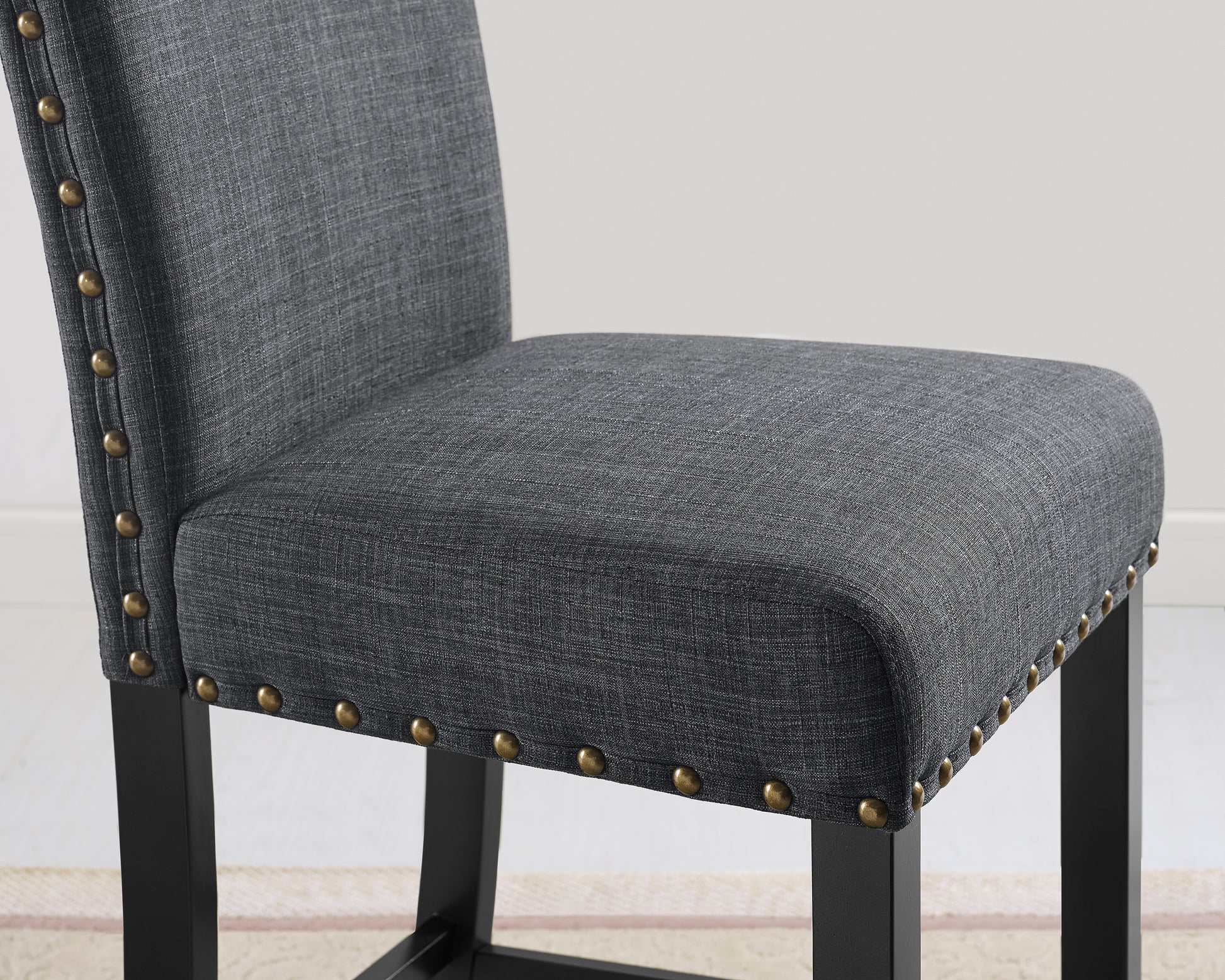 Gray linen bar stool seat with brass nailhead trim and dark wood legs