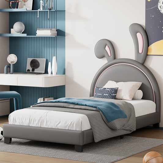 Grey upholstered twin bed with bunny ears headboard