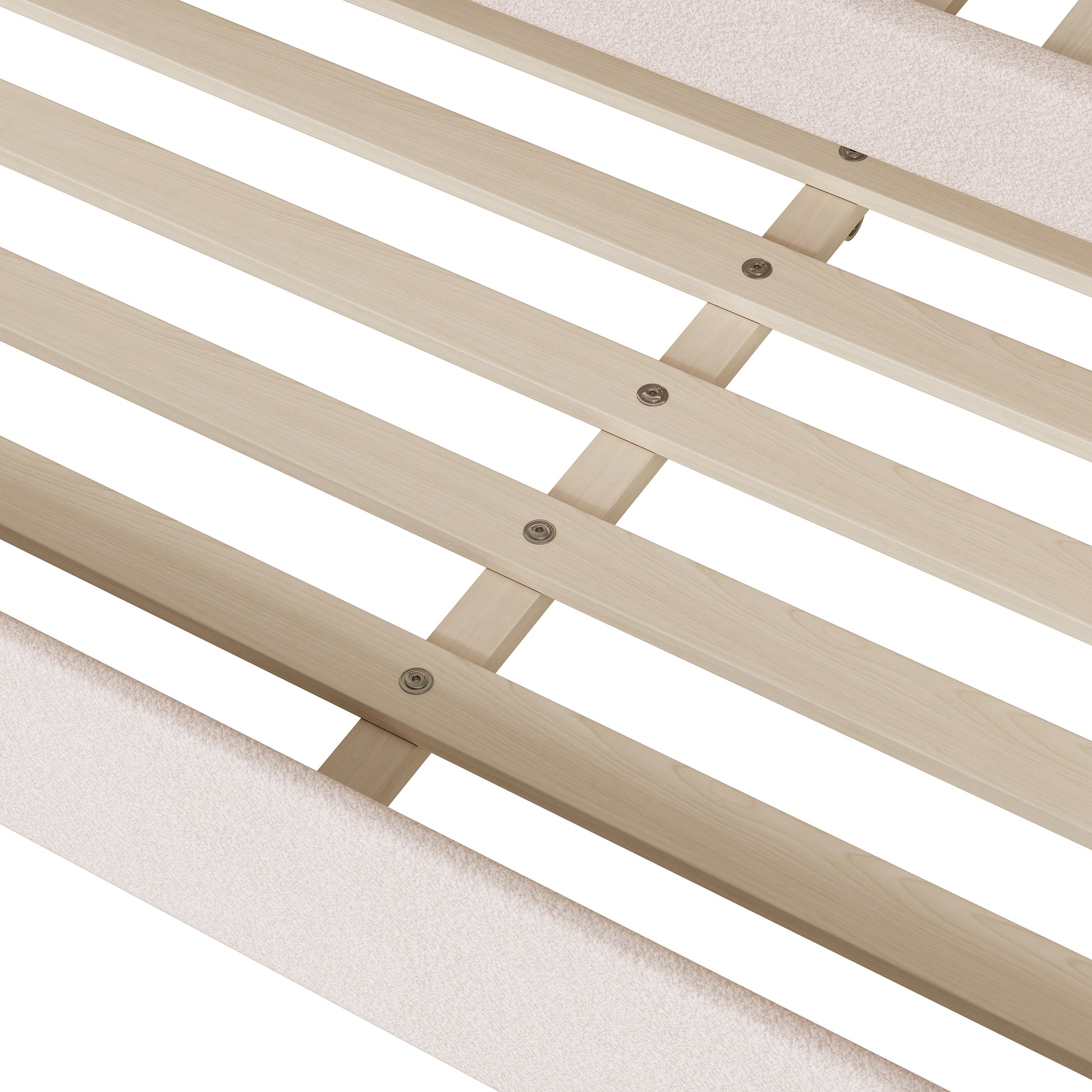 Closeup of a wooden bed frame with light beige upholstered side rails