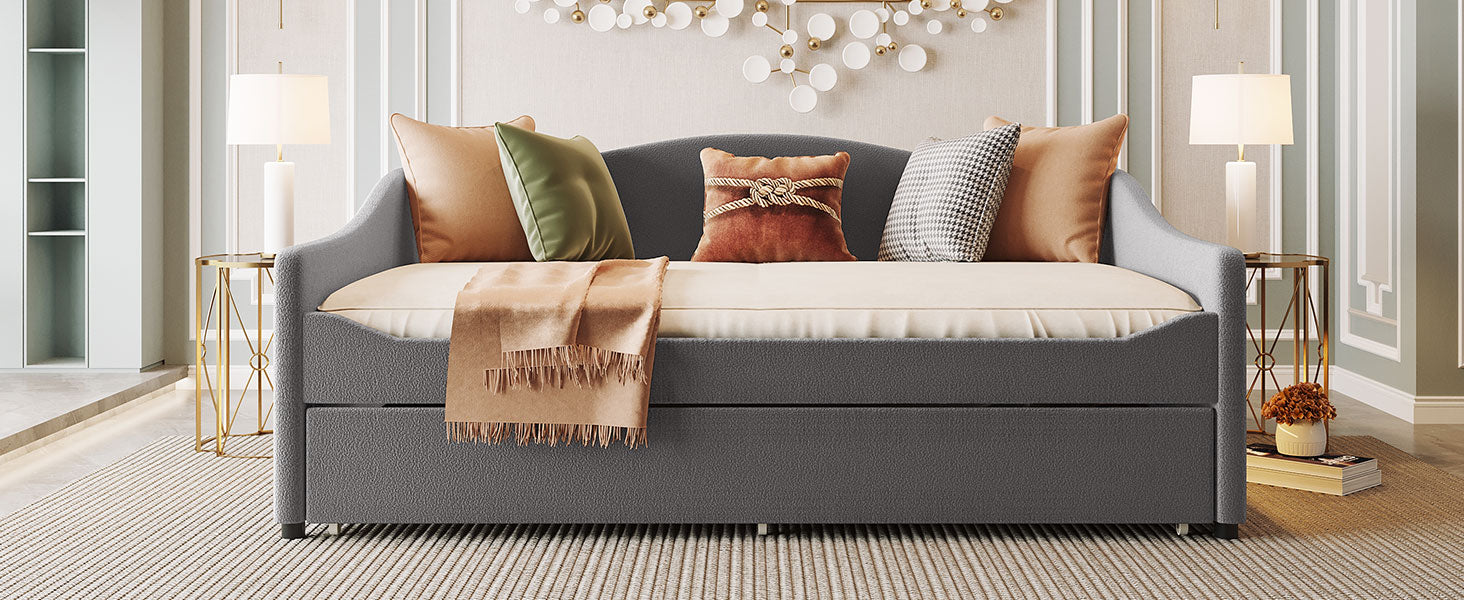 Dark gray upholstered daybed with pullout trundle and decorative pillows