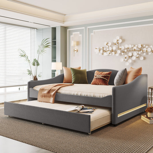 Dark gray upholstered daybed with trundle and accent pillows