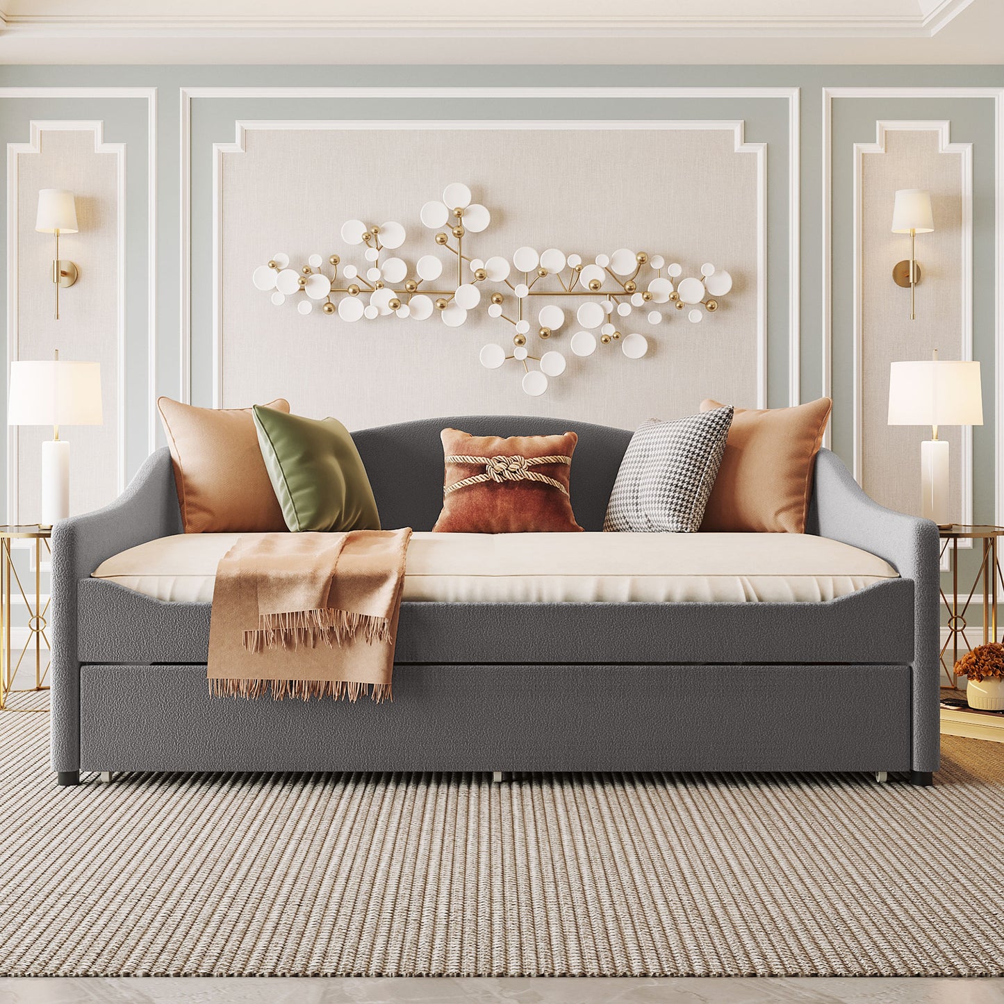 Dark gray upholstered daybed with pullout trundle adorned with plush accent pillows and throw