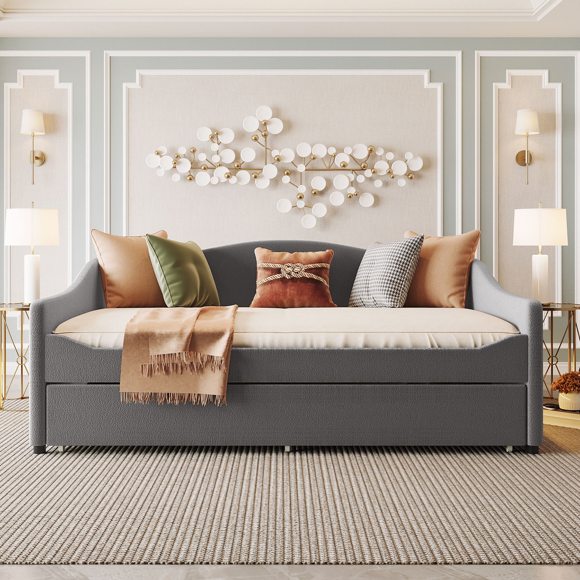 Dark gray upholstered daybed with pullout trundle adorned with plush accent pillows and throw