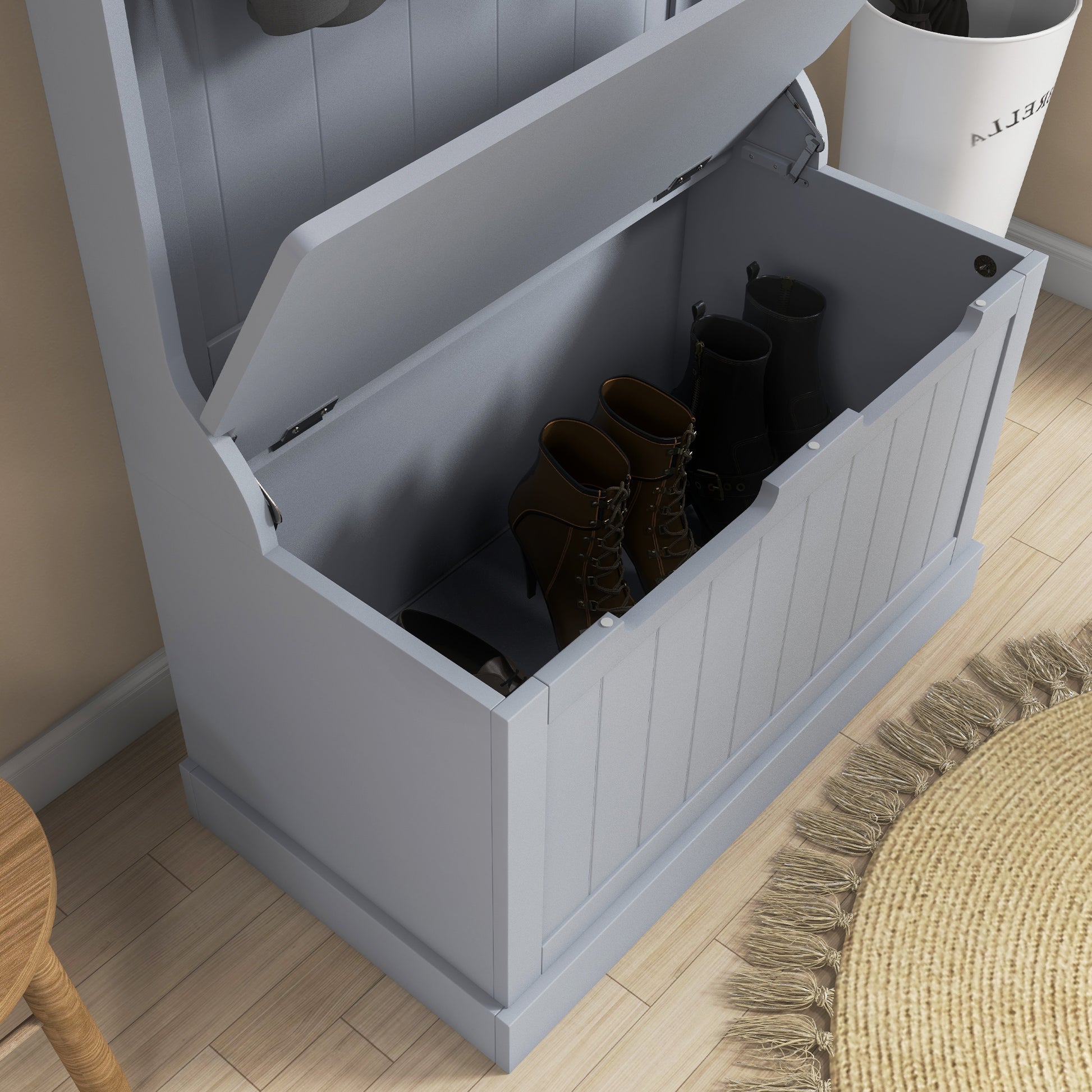 Grey wooden shoe bench with lid open storing brown laceup boots and black riding boots