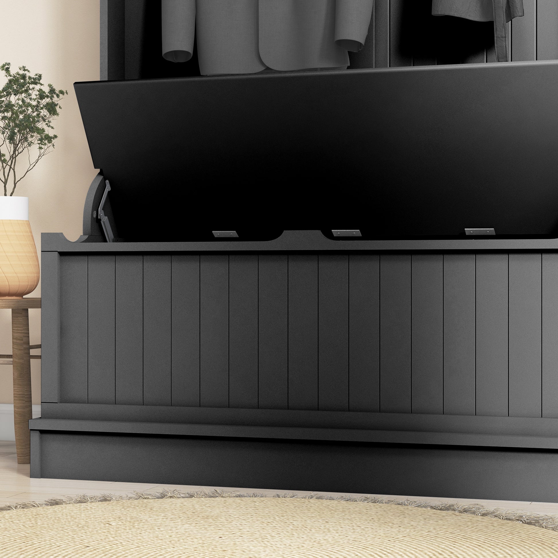 Black painted wooden blanket chest with hinged lid open displaying interior storage