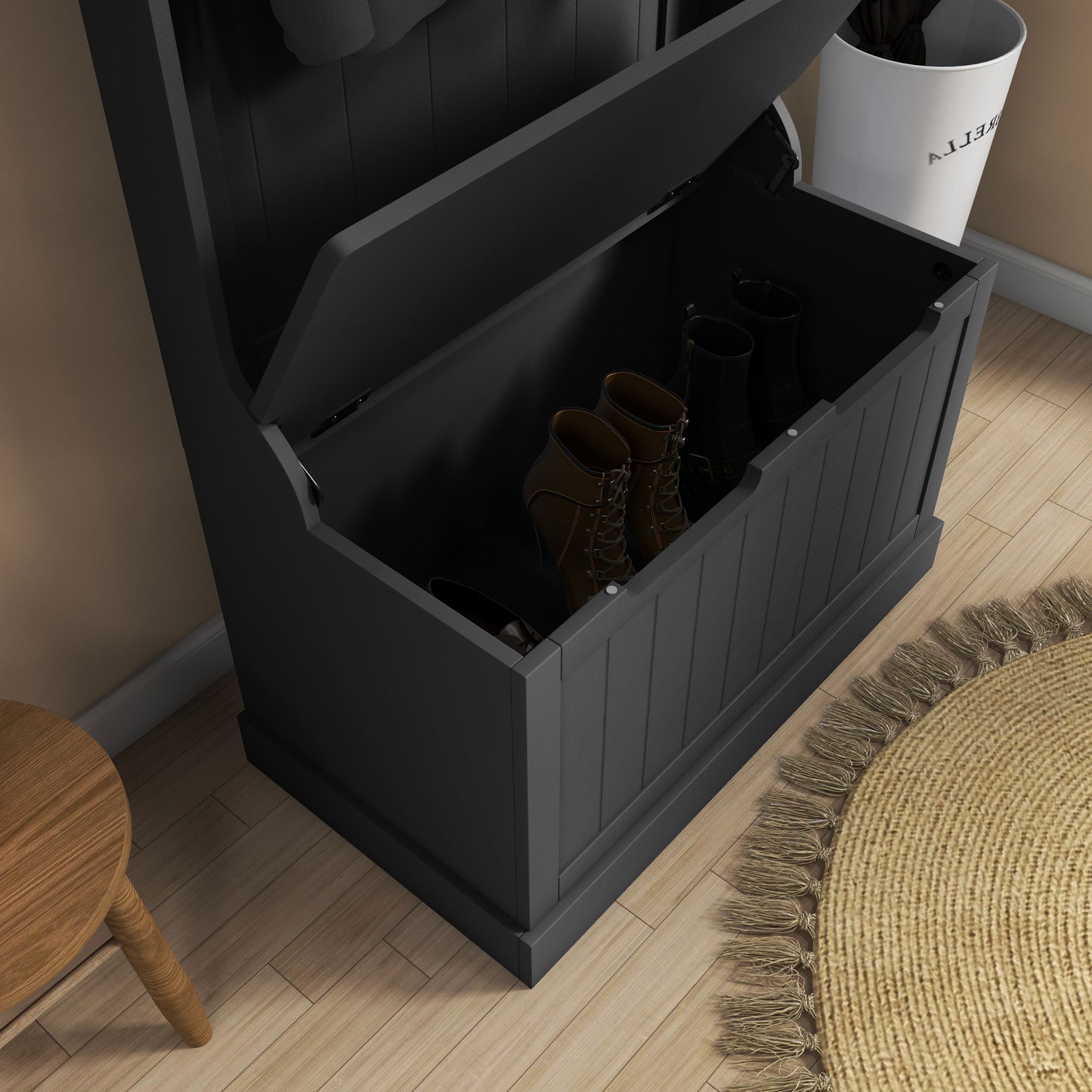 Black wood entryway bench with storage holding brown laceup boots and black wellington boots