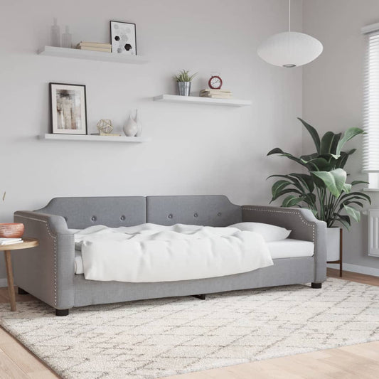 Gray fabric daybed with tufted back cushions and silver nailhead trim