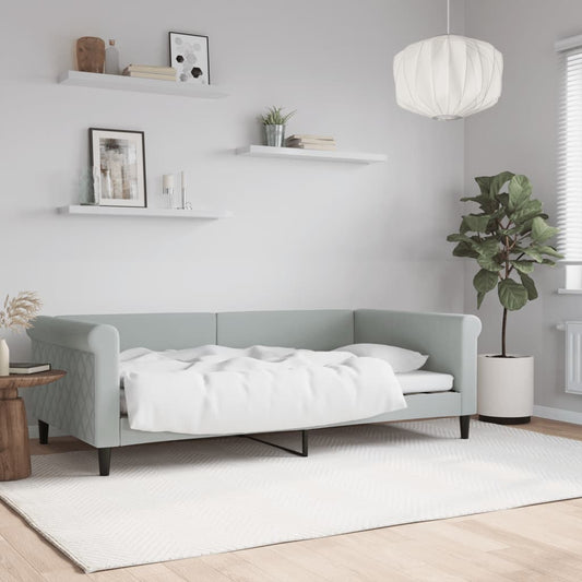 Light blue upholstered sofa bed with white linens tufted arms and dark wooden legs