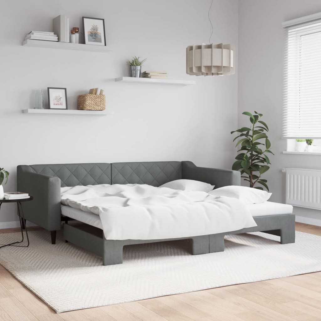 Grey upholstered sofa bed with diamond tufting and white bedding