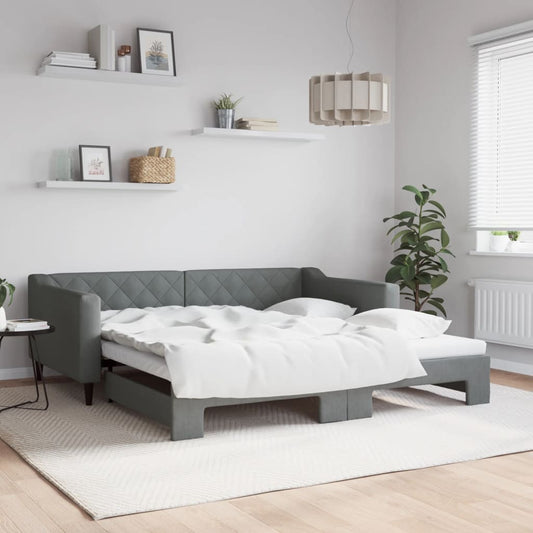 Grey upholstered sofa bed with diamond tufting and white bedding