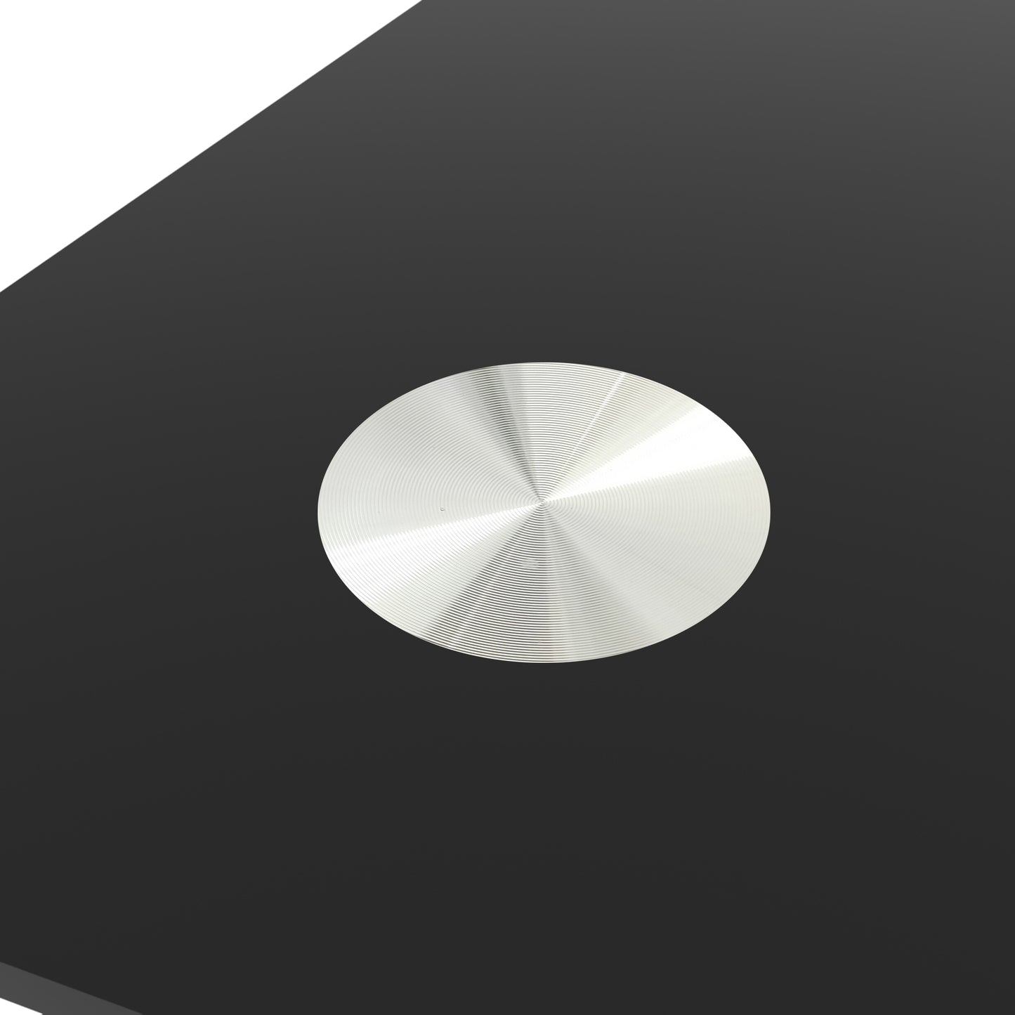 Brushed aluminum coaster with concentric circle design on black surface
