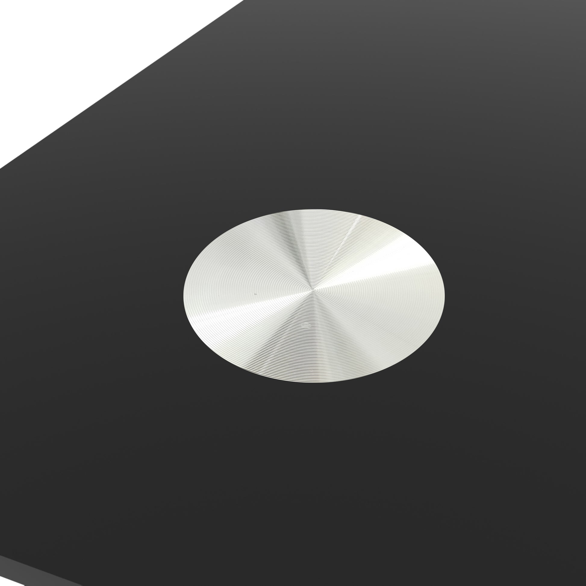 Brushed aluminum coaster with concentric circle design on black surface