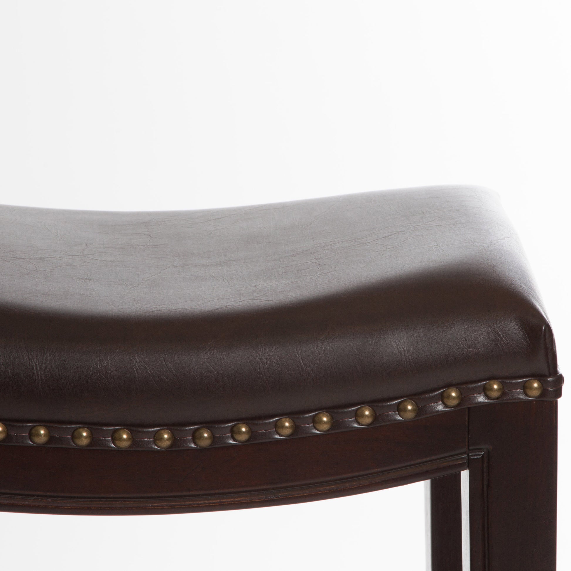 Dark brown faux leather saddle stool seat with brass nailhead trim