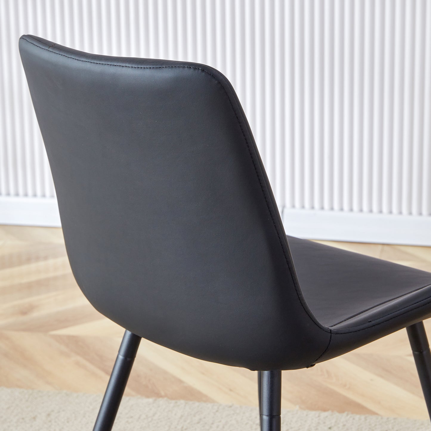 Black faux leather dining chair back and seat with metal legs