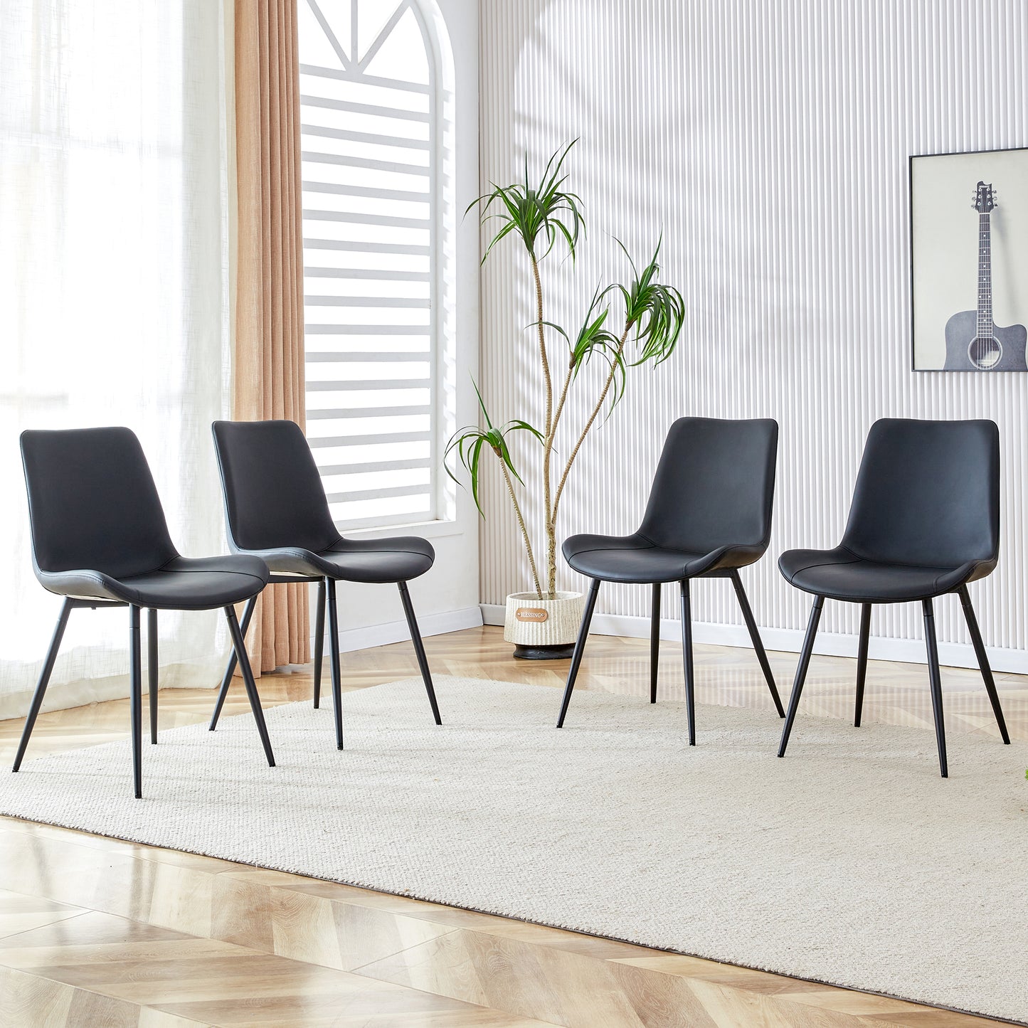 Four sleek black dining chairs with metal legs arranged in a modern living space