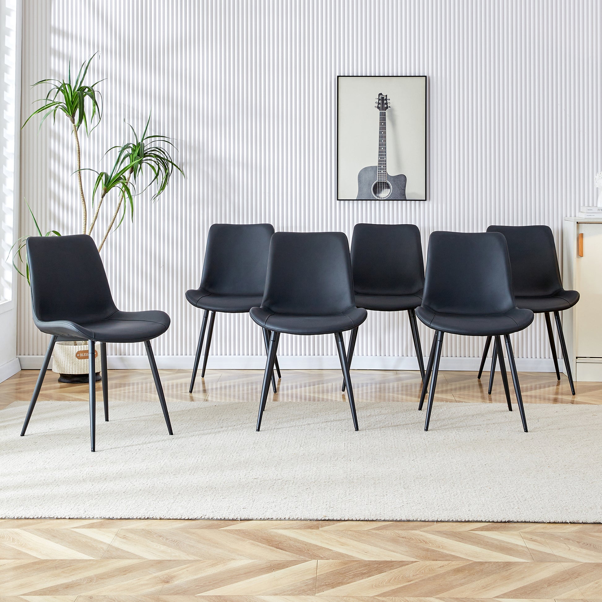 Set of six black faux leather dining chairs with slim metal legs