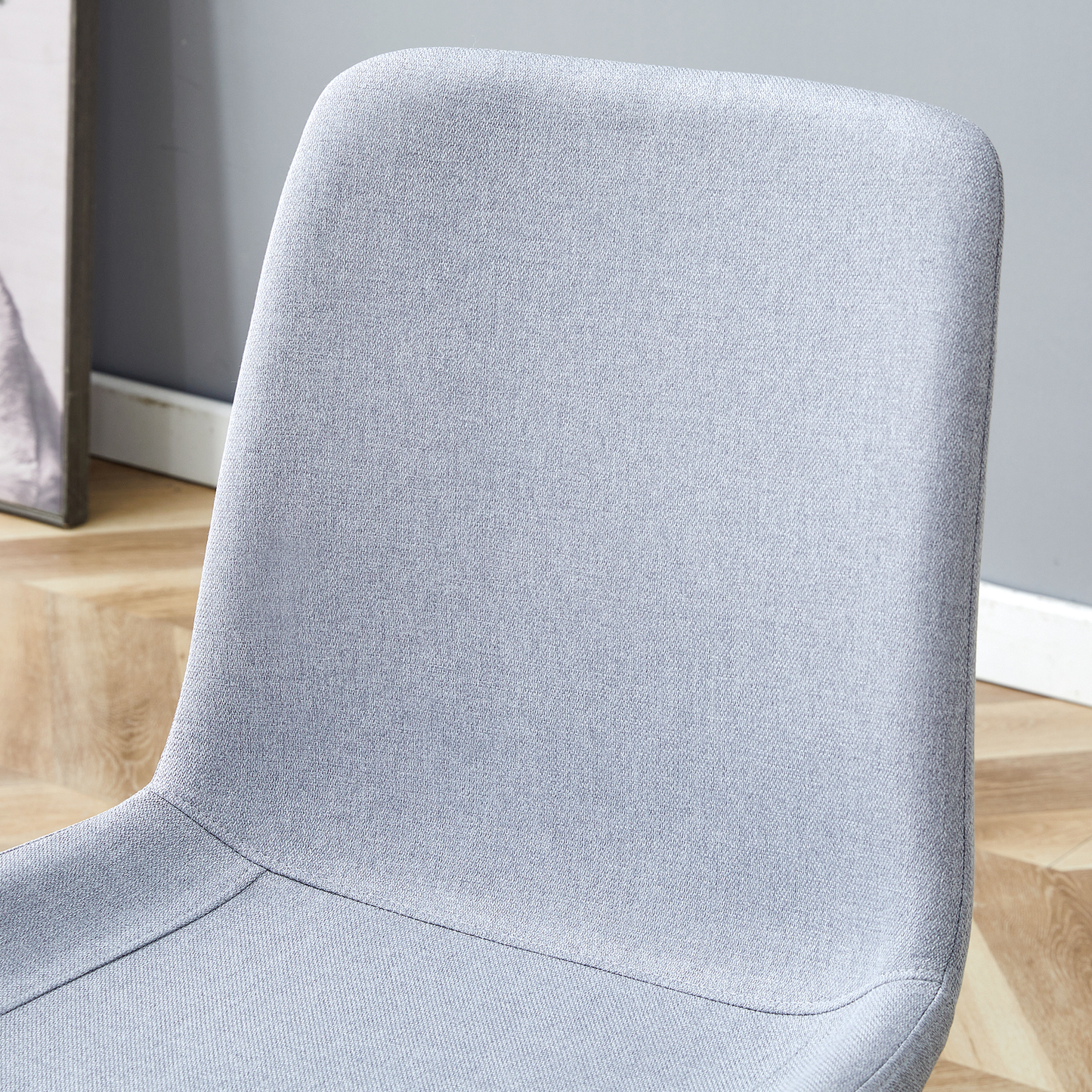 Closeup of a textured light grey fabric dining chair back