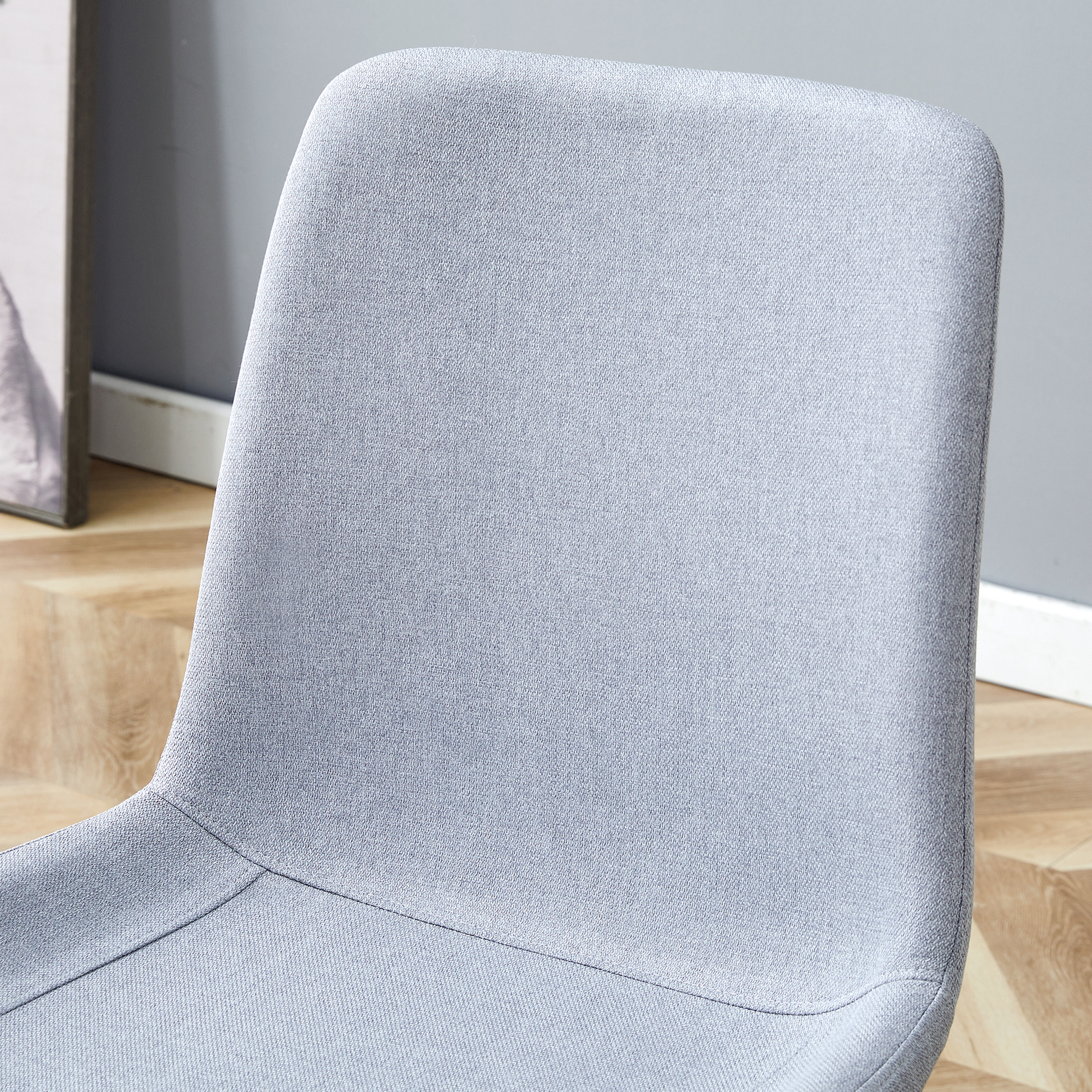 Closeup of a textured light grey fabric dining chair back