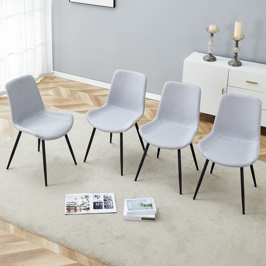 Four light grey fabric dining chairs with black metal legs arranged around a rug