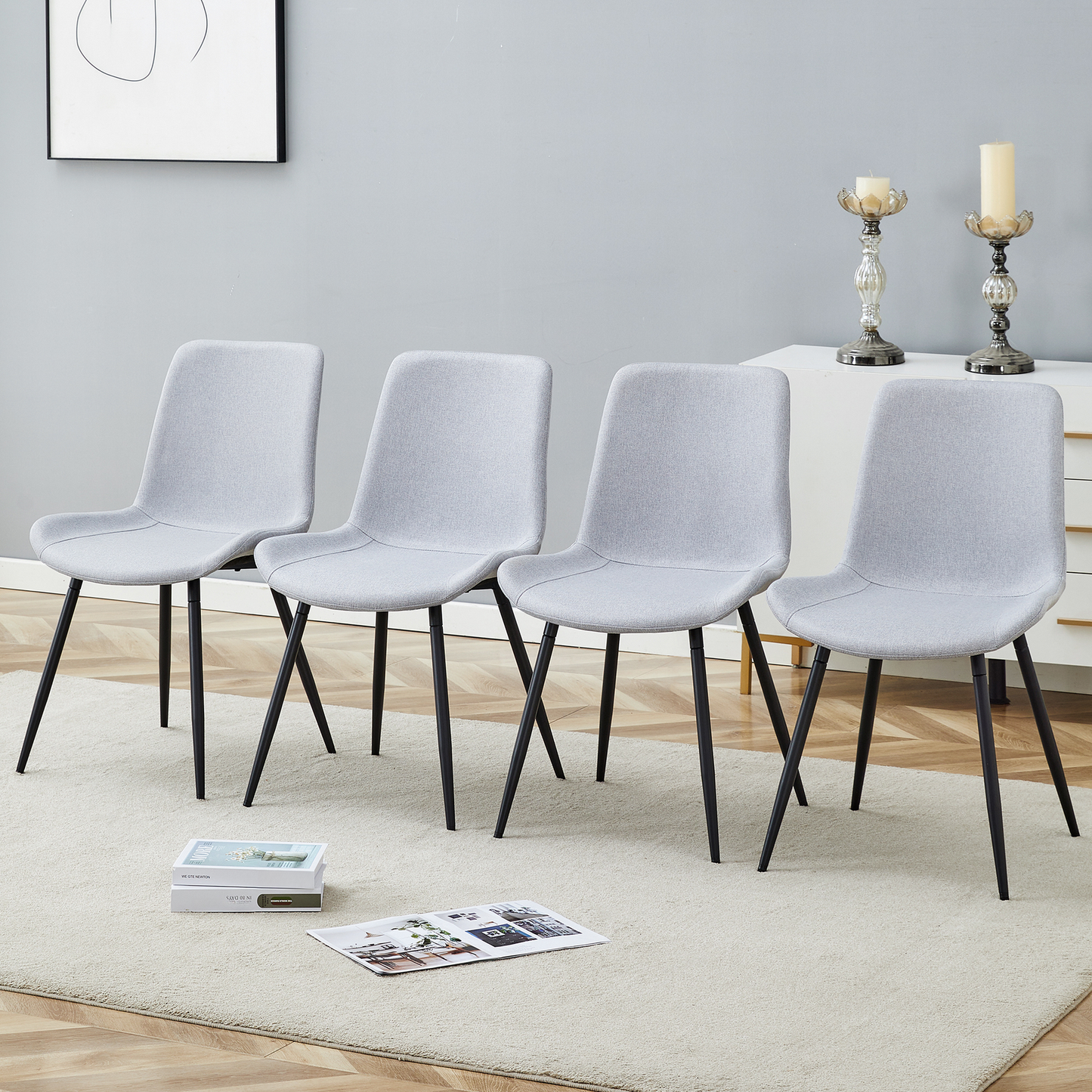 Set of four light gray fabric dining chairs with black metal legs