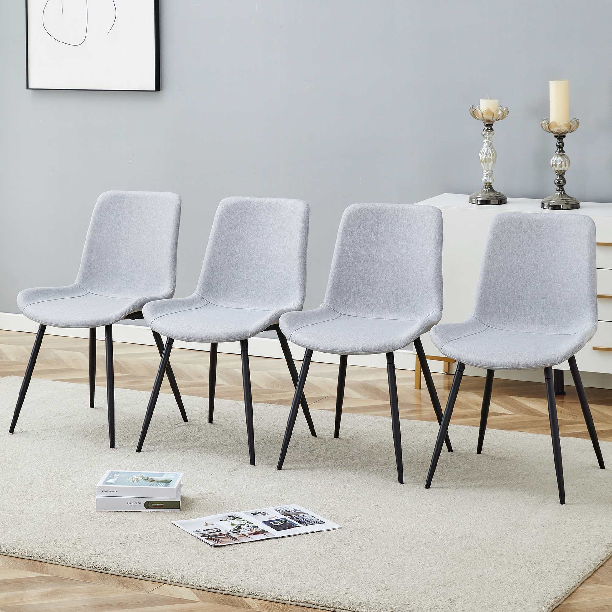 Set of four light gray fabric dining chairs with black metal legs