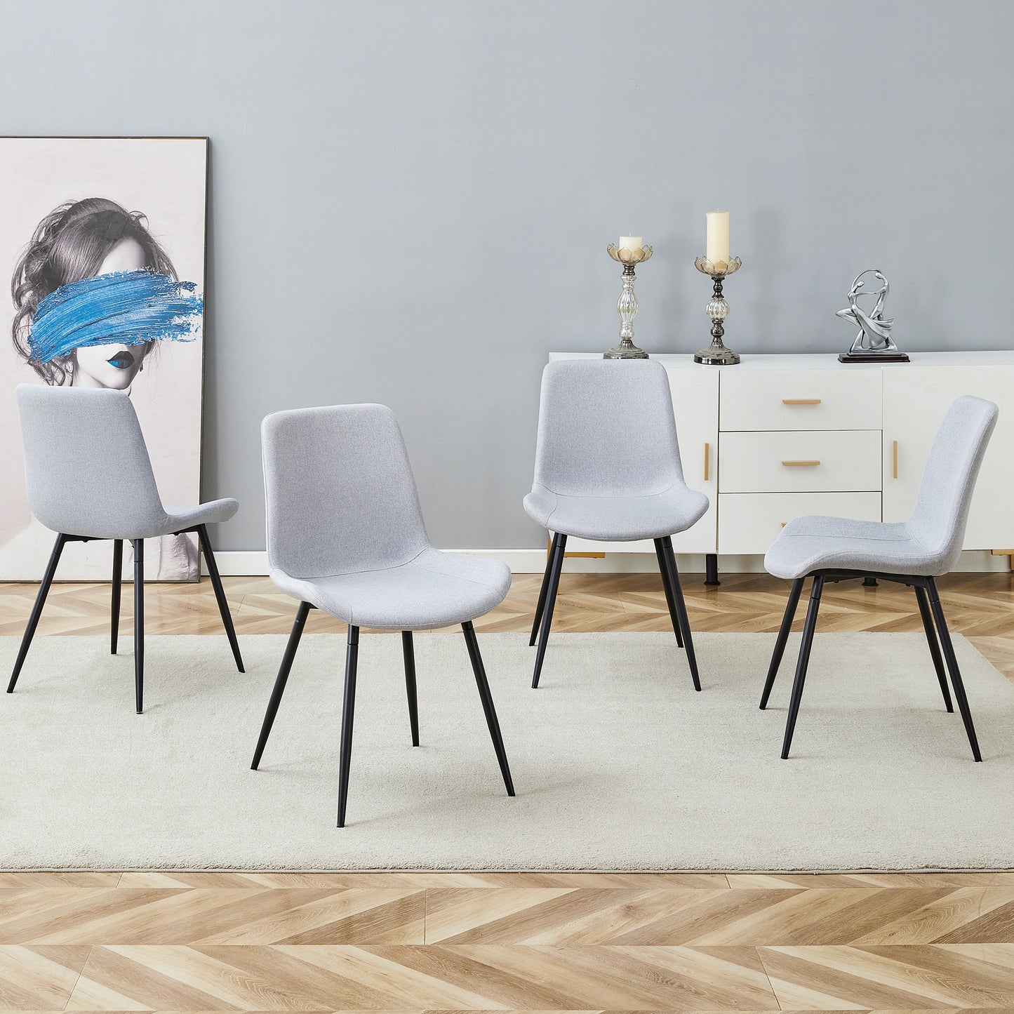 Set of four light grey fabric dining chairs with black metal legs