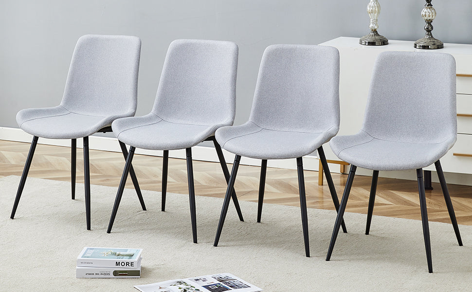 Set of four light grey fabric dining chairs with black metal legs