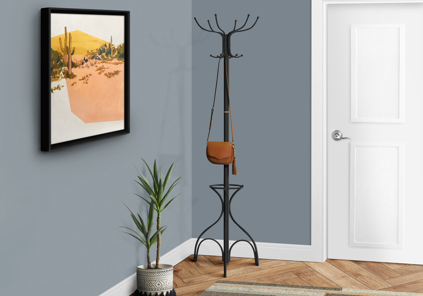 Black metal coat rack with ornate base and  hooks