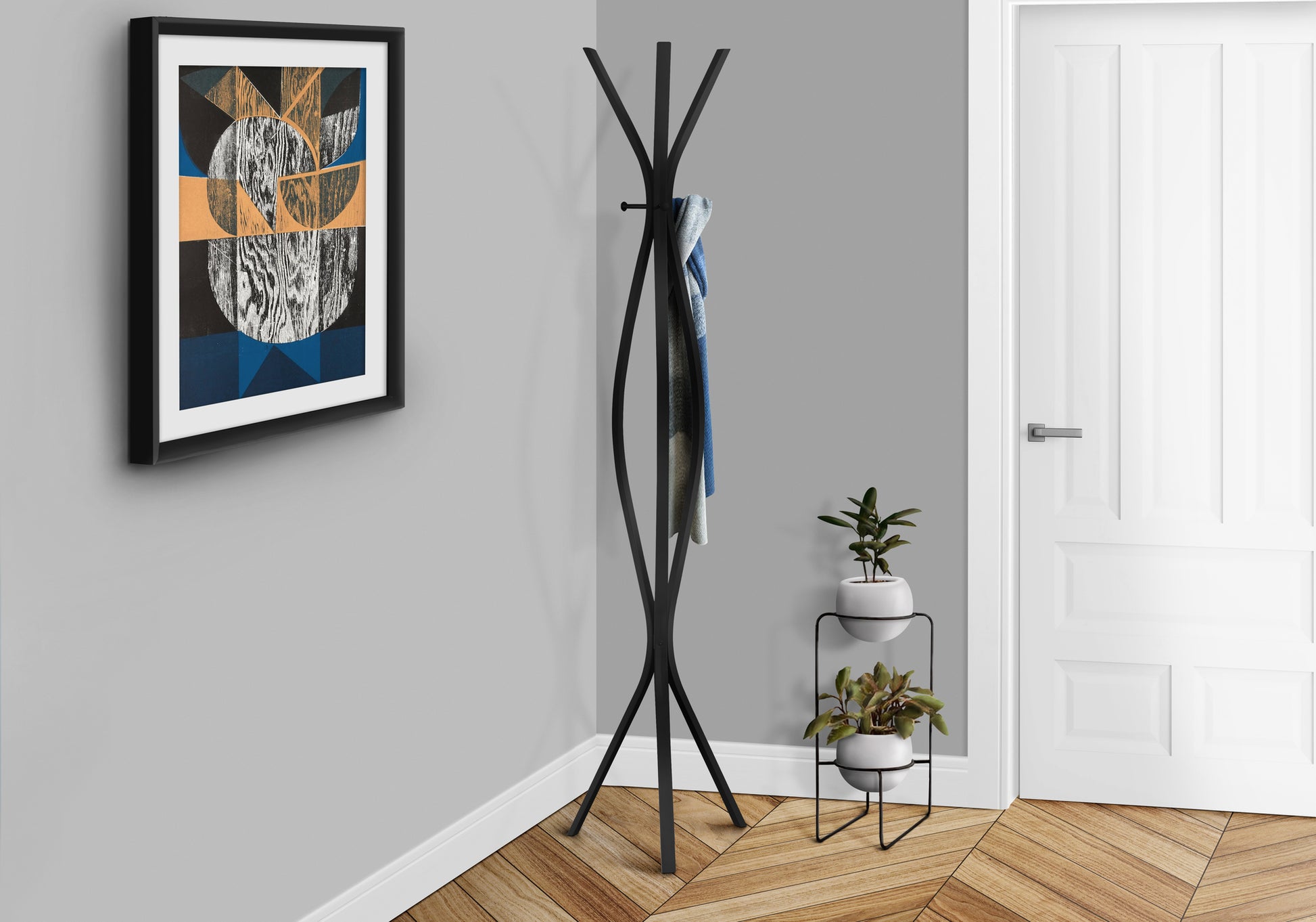 Black modern coat rack with curved legs holding a blue and grey scarf