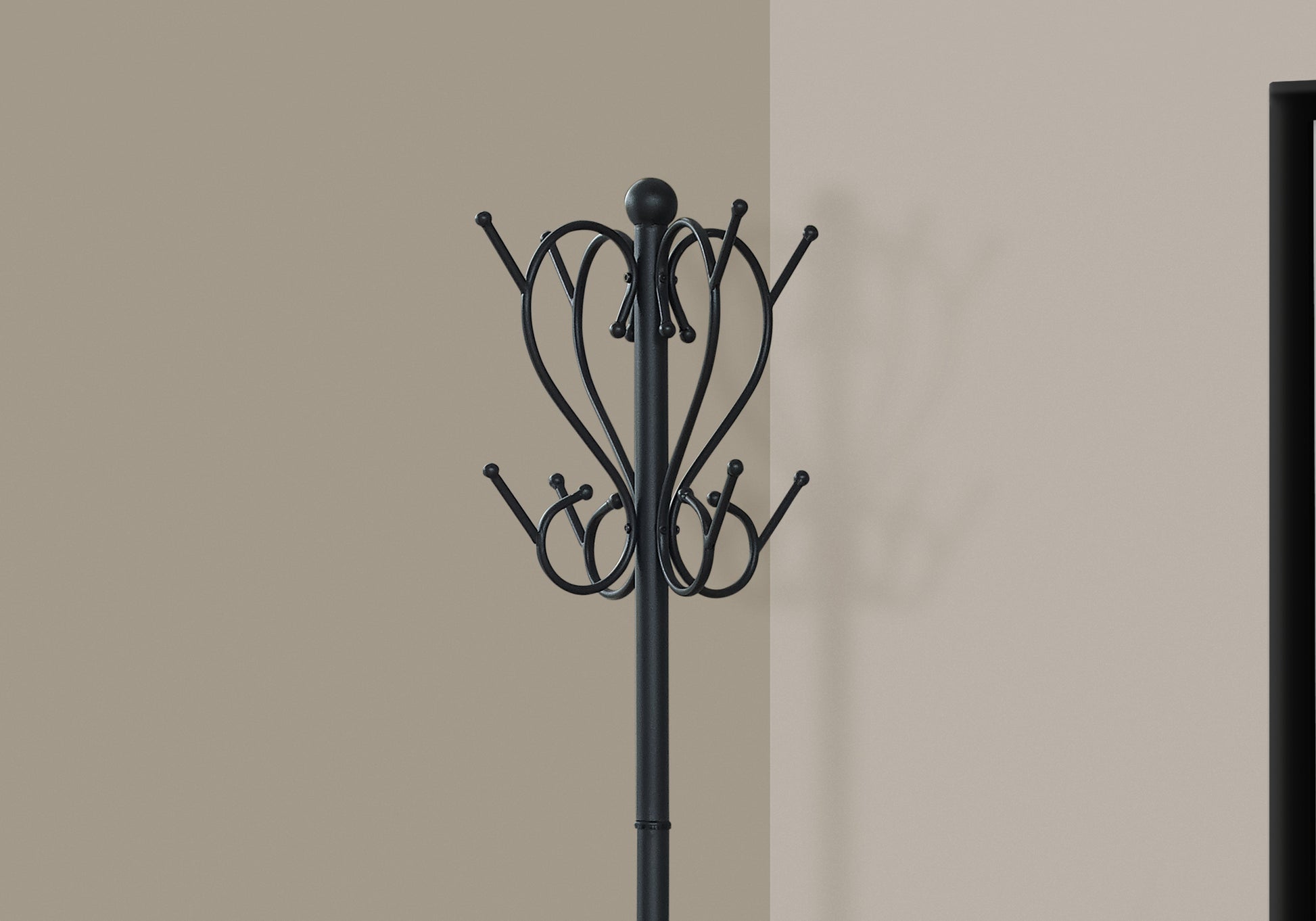 Black metal coat rack with ornate scroll design and multiple hooks