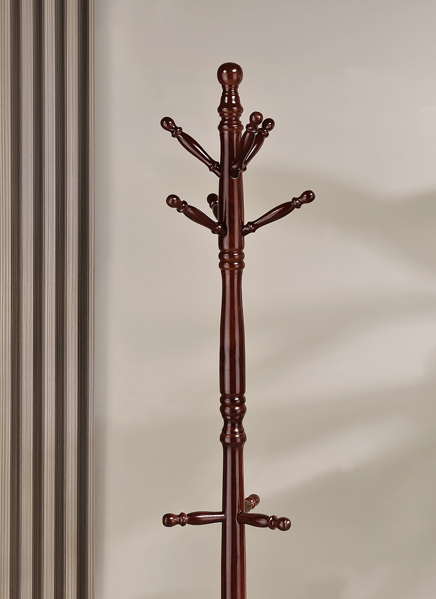 Dark wood entryway coat rack with multiple hanging pegs