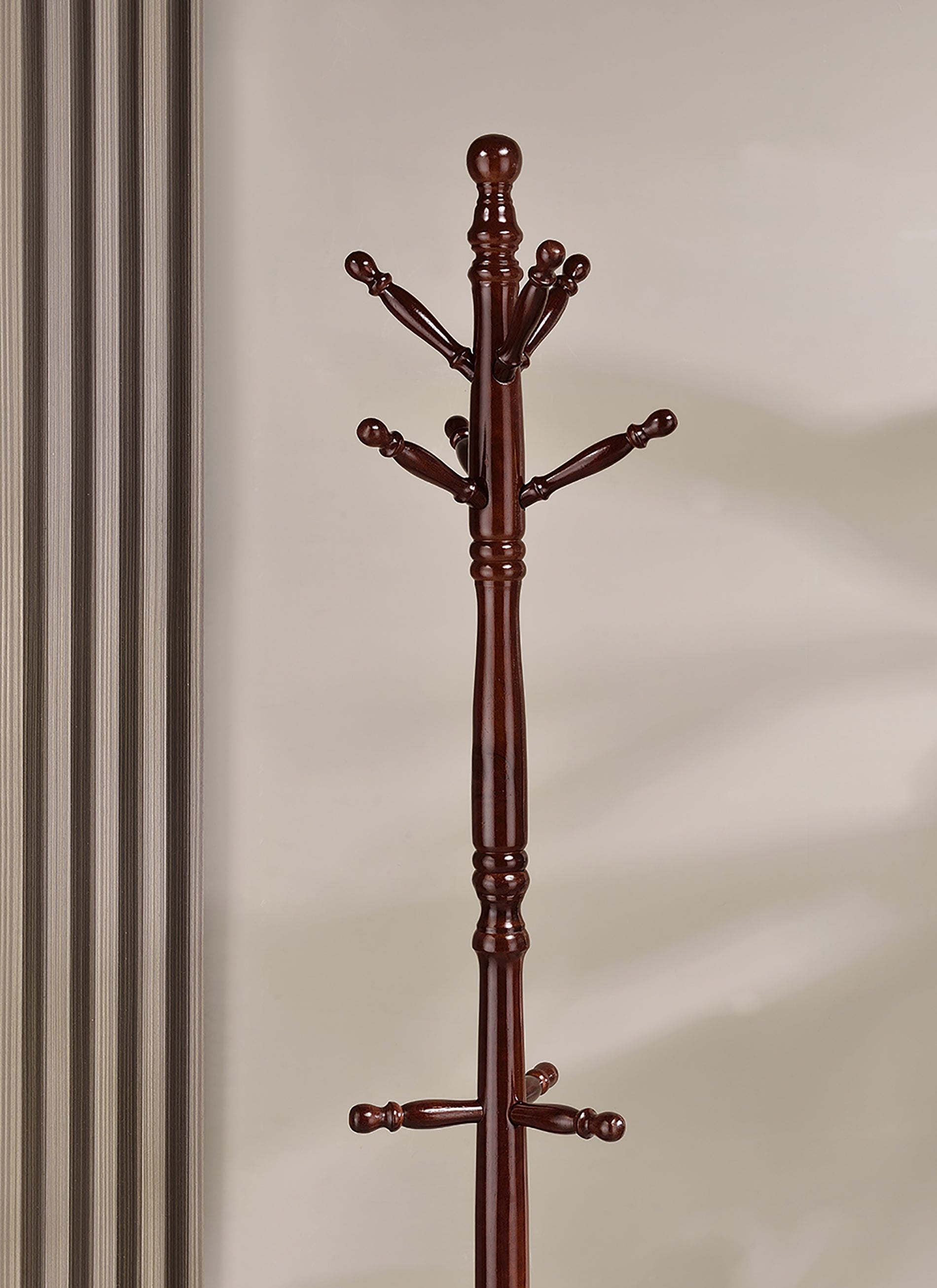 Dark wood entryway coat rack with multiple hanging pegs