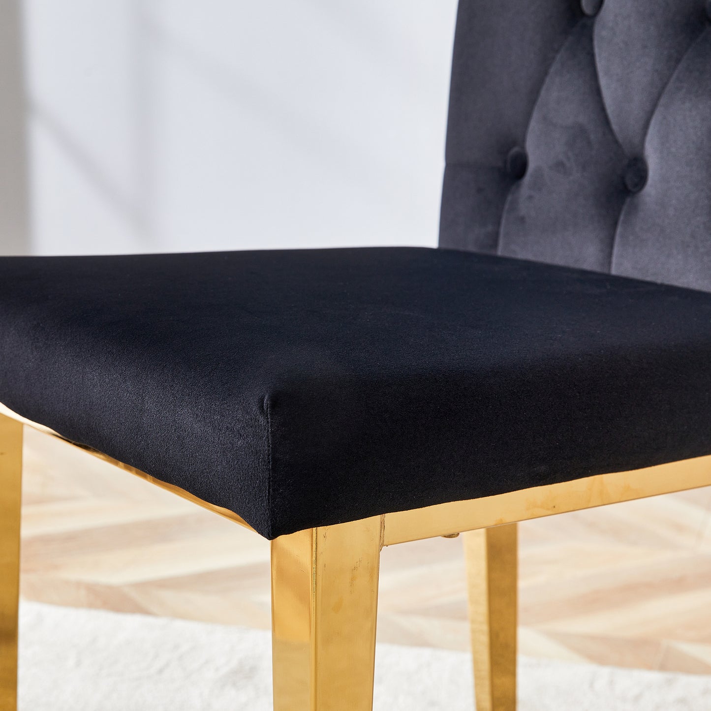 Black velvet dining chair with tufted back and gold legs