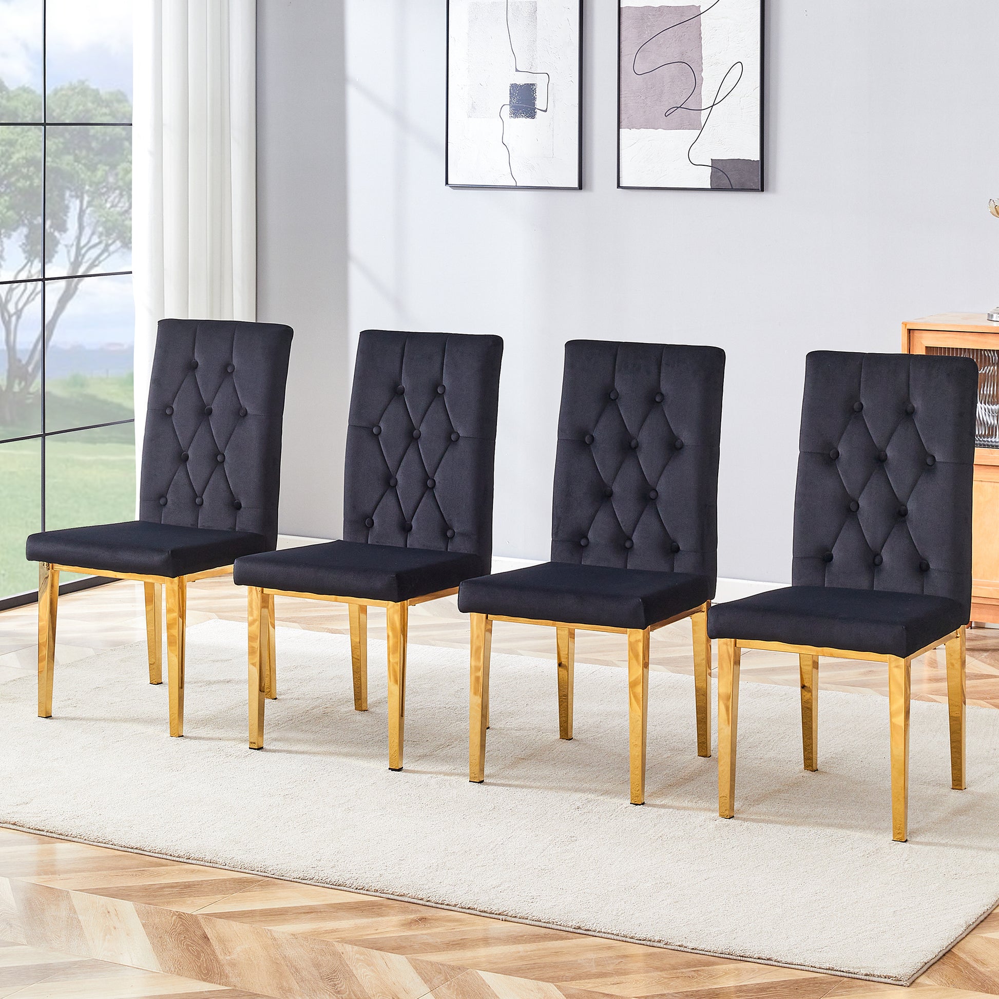 Four black velvet dining chairs with tufted backs and gold legs