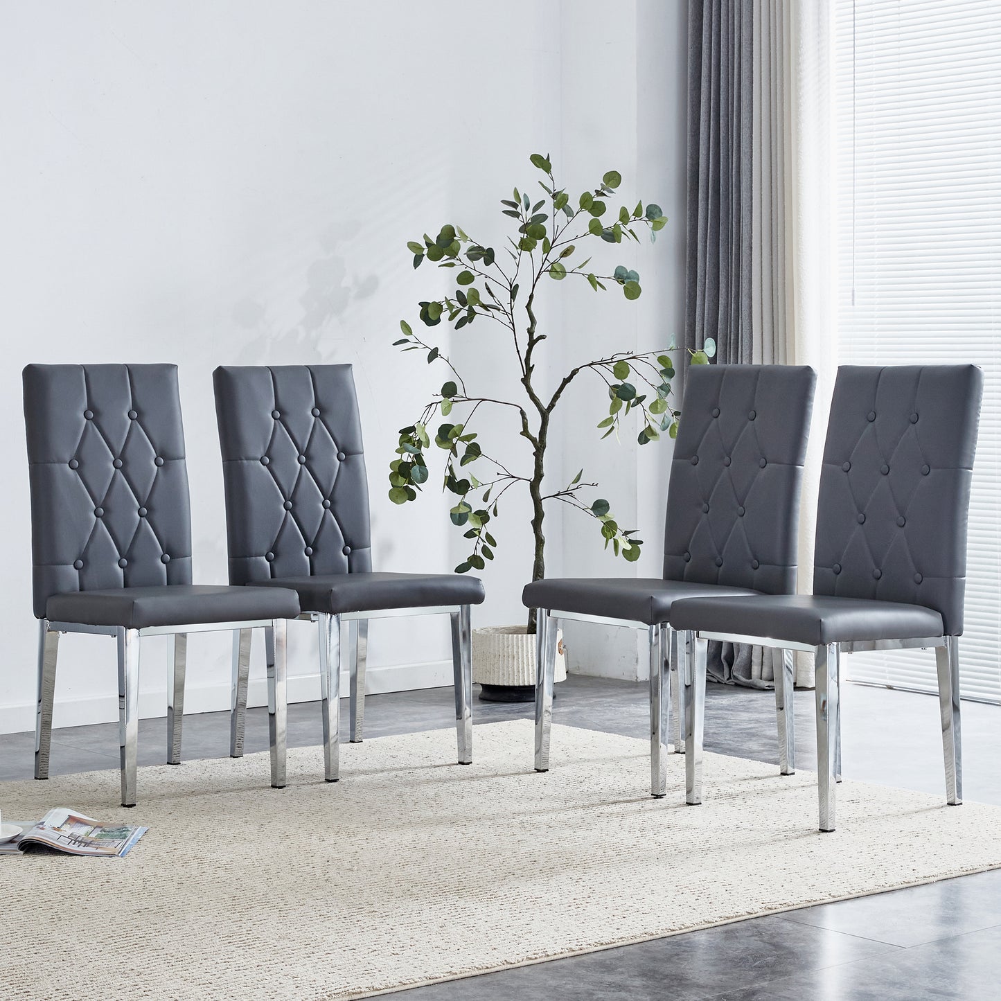 Four dark grey faux leather dining chairs with tufted backs and chrome legs