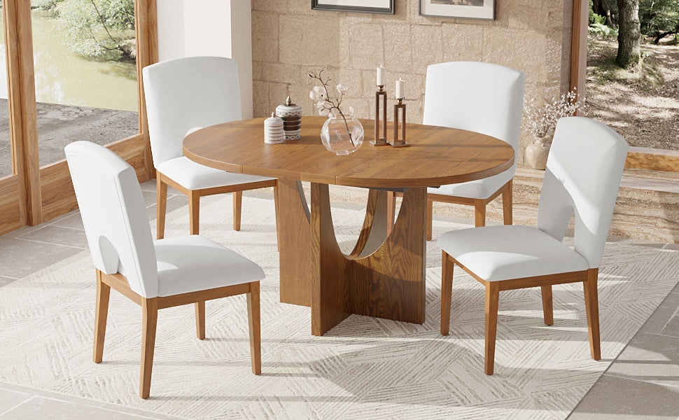 Round oak dining table with four white upholstered chairs